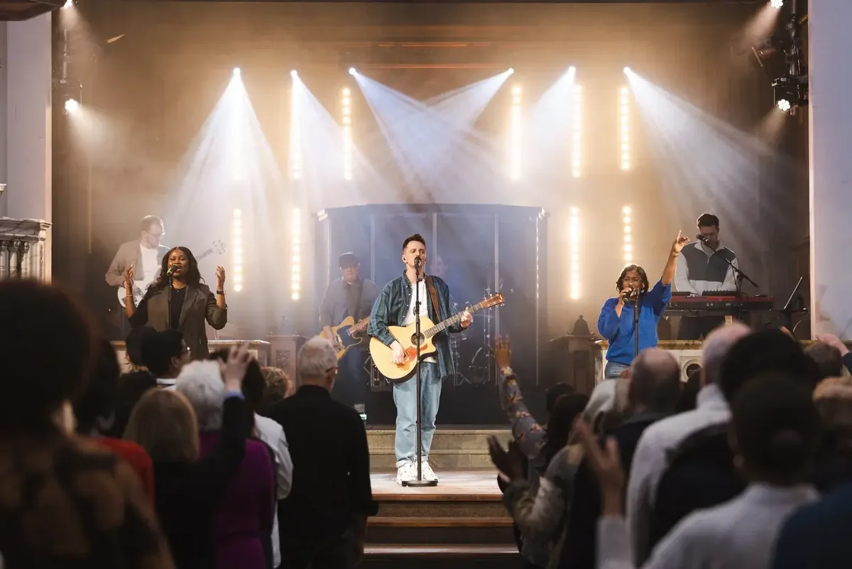 The HTB Worship Band leading a packed congregation, hands raised